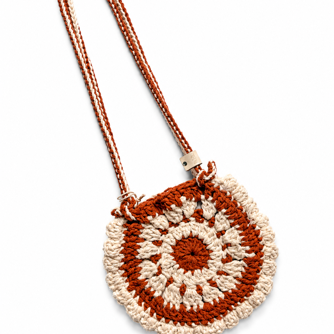 Bolso Boho tejido artesanal en crochet terracota con diseño de flor en tonos rosa y marfil.