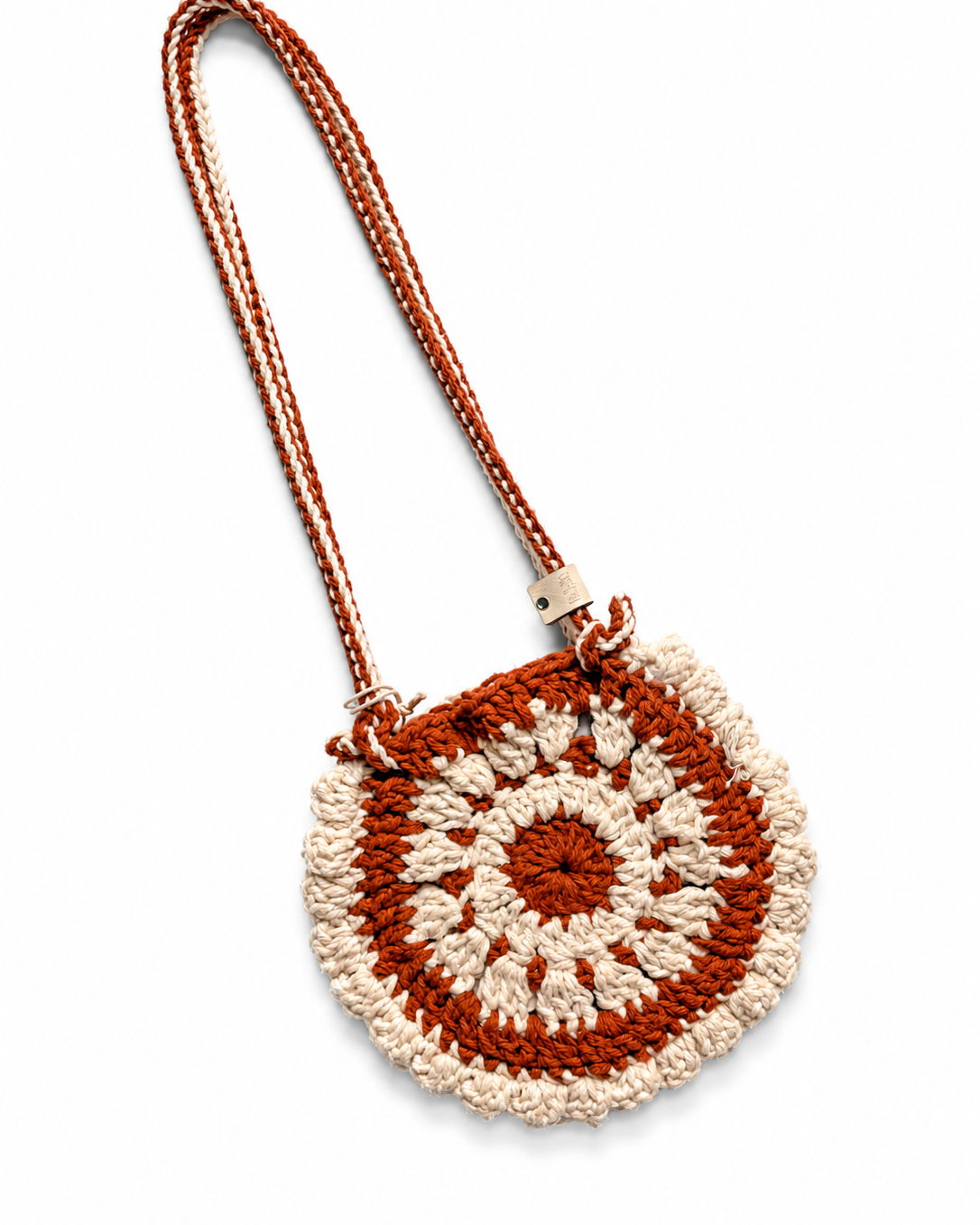 Bolso Boho tejido artesanal en crochet terracota con diseño de flor en tonos rosa y marfil.