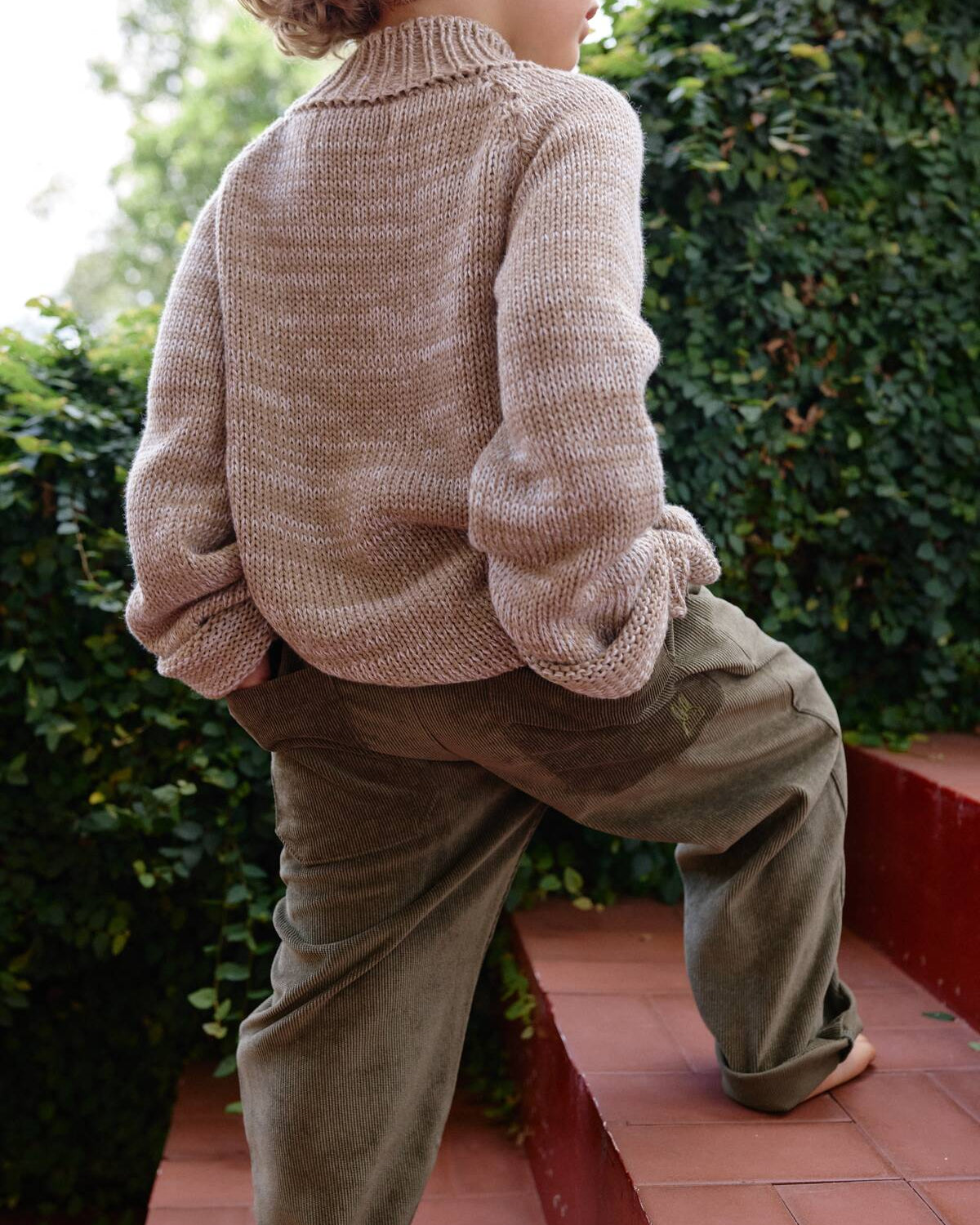 Niño usando Pantalón Noah Verde Oliva en pana combinado con saco tejido de La Tutu.